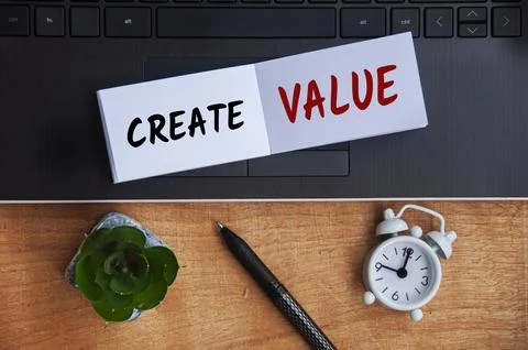 Create value text on notepad with laptop, clock, pen and wooden background... 写真素材