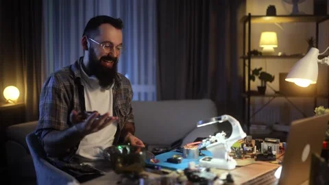 Creating and piloting drones. A young, bearded man in a plaid shirt tests his Stock Footage 261145659