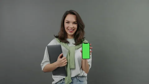 Creating applications for a smartphone.Woman with smartphone on which chromakey Stock Footage 233342118