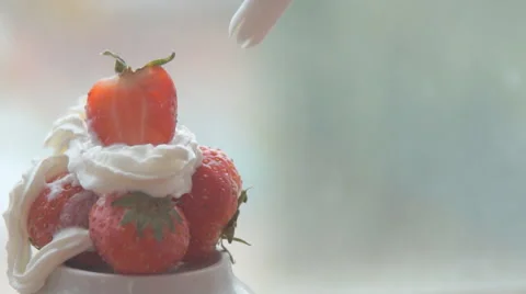 Creating a bed of sweet white whipped cream for a red ripe strawberry Stock Footage 68955190