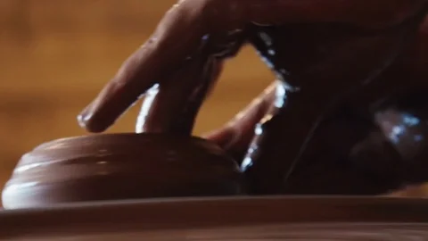 Creating a clay pot.Potter.Hands working on pottery wheel, shaping a clay pot Stock Footage 76984787