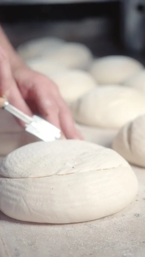 Creating Decorative Scores on Bread Dough with a Blade Stock Footage 344312977