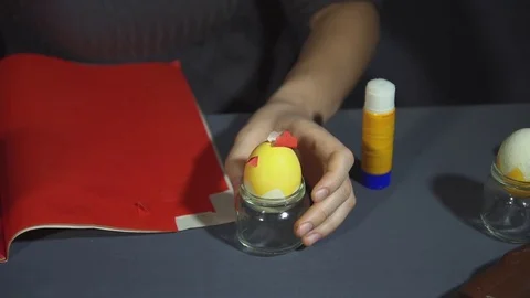 Creating easter chicken from the shell by hand on a grey table. Stock Footage 73148942