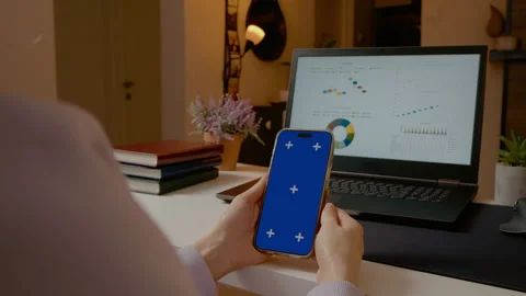 Creating engaging content with blue screen phone in home office setup Stock Footage 305146308