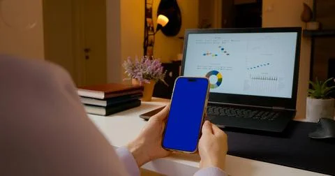 Creating engaging content with blue screen phone in home office setup Stock Photos