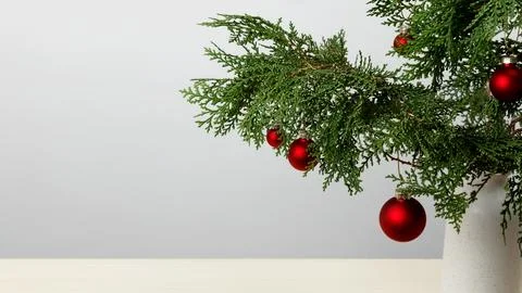 Creating a festive display vase with thuja branches and hanging Christmas orn Stock Photos