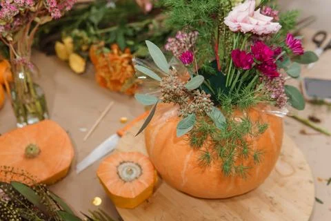 Creating a floral composition in a pumpkin. Making decor with your own hands. Stock Photos