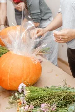 Creating a floral composition in a pumpkin. Making decor with your own hands. Stock Photos
