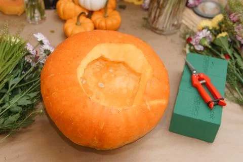 Creating a floral composition in a pumpkin. Making decor with your own hands. Stock Photos
