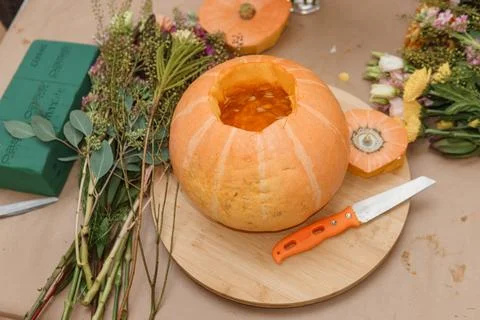 Creating a floral composition in a pumpkin. Making decor with your own hands. Stock Photos