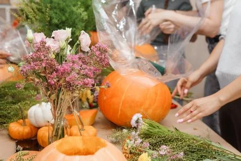 Creating a floral composition in a pumpkin. Making decor with your own hands. Stock Photos