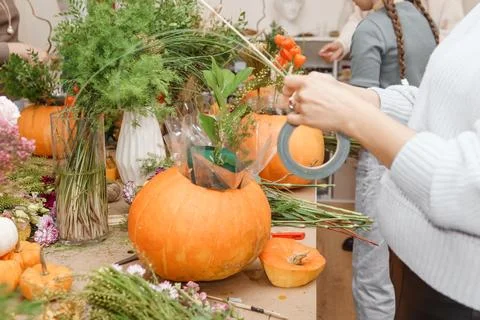 Creating a floral composition in a pumpkin. Making decor with your own hands. Stock Photos