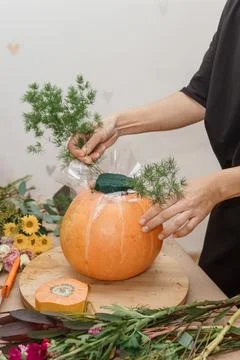 Creating a floral composition in a pumpkin. Making decor with your own hands. Stock Photos