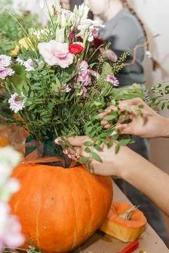 Creating a floral composition in a pumpkin. Making decor with your own hands. Stock Photos