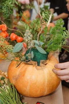 Creating a floral composition in a pumpkin. Making decor with your own hands. Stock Photos