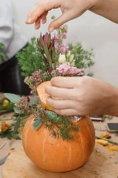 Creating a floral composition in a pumpkin. Making decor with your own hands. Stock Photos