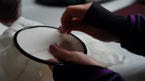 Creating intricate lace designs through hand sewing in a cozy workspace Stock Footage 289548878