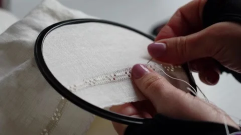 Creating intricate lace designs through hand sewing in a cozy workspace. Stock Footage 300285062