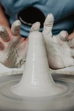Creating a jar or vase of white clay close-up. Woman hands making clay jug. Stock Photos
