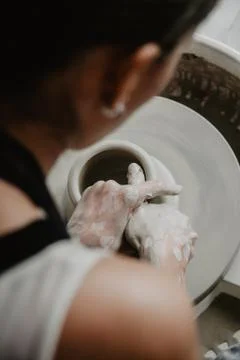 Creating a jar or vase of white clay close-up. Woman hands making clay jug. Foto stock