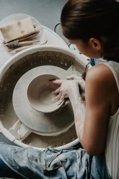Creating a jar or vase of white clay close-up. Woman hands making clay jug. Stock Photos