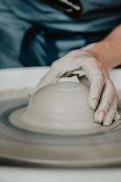Creating a jar or vase of white clay close-up. Woman hands making clay jug. Stockfoto's