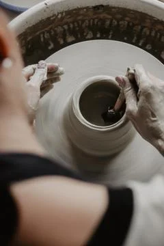 Creating a jar or vase of white clay close-up. Woman hands making clay jug. Stock Photos