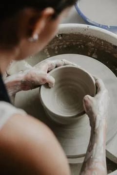 Creating a jar or vase of white clay close-up. Woman hands making clay jug. Foto stock