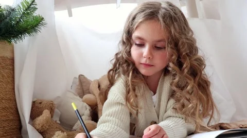 Creating magical moments while reading in a cozy blanket fort adventure Stock Footage 296323003