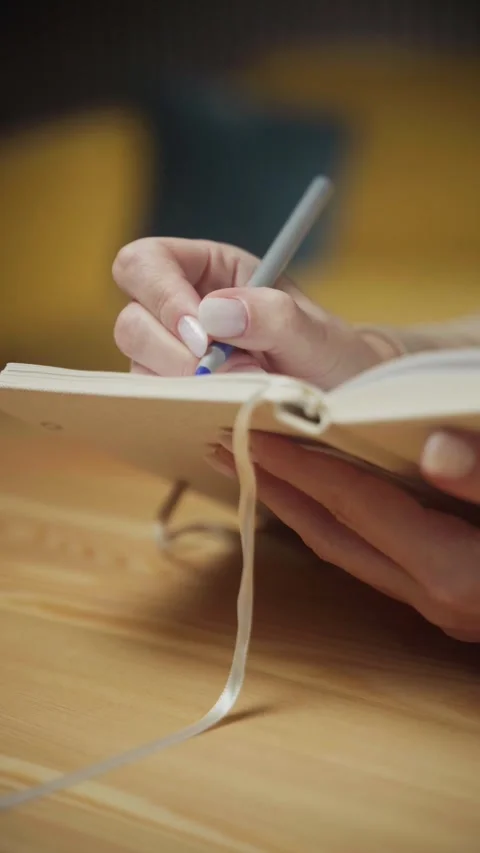 Creating meaningful notes in a cozy setting with a pen and notebook Stock Footage 303768252