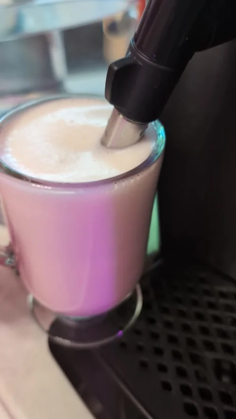 Creating milk foam for coffee drinks using an espresso machine in a cafe setting Video stock 332361673
