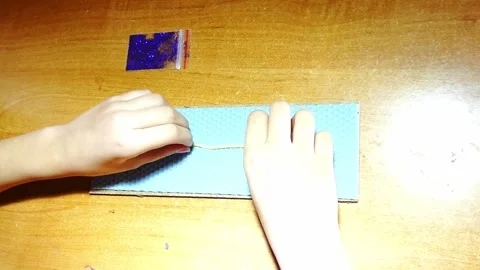 Creating a simple craft project with beads and string on a wooden table during t Stock Footage 328415924