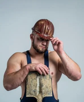 Creating solid foundation. athletic builder in helmet. sexy man with shovel Stock Photos