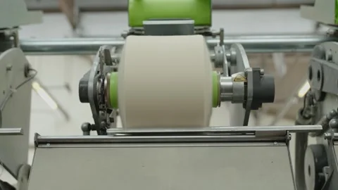 Creating a spool of white on a machine in a factory Stock Footage 291870639