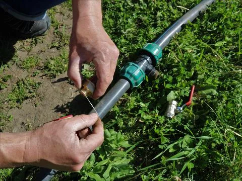 Creating a tightness of the tap using a thread in the irrigation system Stock Photos