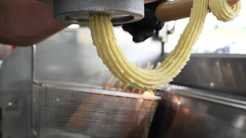 Creating a unique churro hot dog in a commercial kitchen Stockbeeldmateriaal 331955912