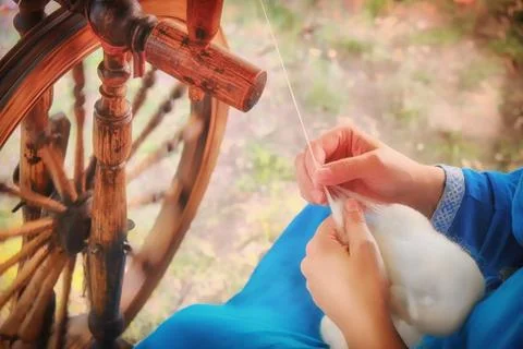 Creating yarn threads, close-up. Spinning wheel in nature, rustic style Stock Photos