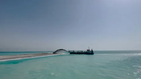 Creation of an artificial island. The construction ship pours sand on the island Stock Footage 238741029