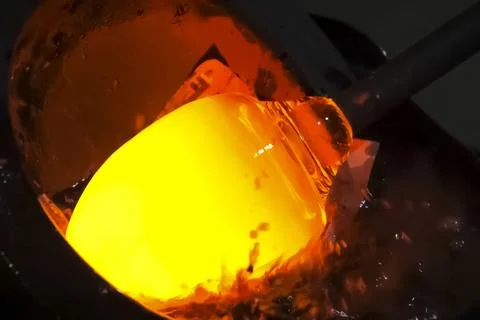 Creation of glass vessels by method of molded blowing of hot glass. Stock Photos