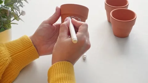 Creation of simple designs on clay pots with a white marker in bright conditions Stock Footage 306643429