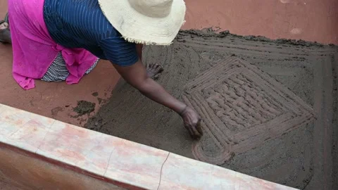 Creation of a traditional pattern on the home patio made with cow dung in Stock Footage 223492609