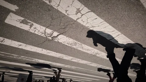 Creative abstract shot of people's shadows walking across the street Vidéo 106007574