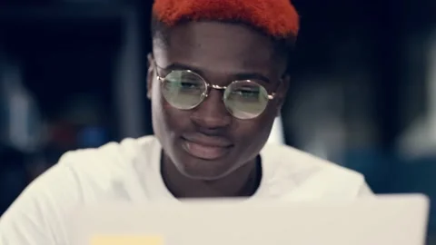 Creative African American student doing laptop work by video chatting with Stock Footage 143642914