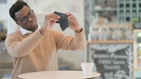 Creative African Man Checking Empty Wallet While Sitting in Cafe Stock Footage 151327017