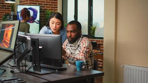 Creative agency employees using computers to develop new graphics interface Stock Photos