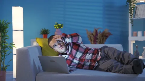 Creative and clever disabled young man lying on sofa at home  Stock Footage 230974736