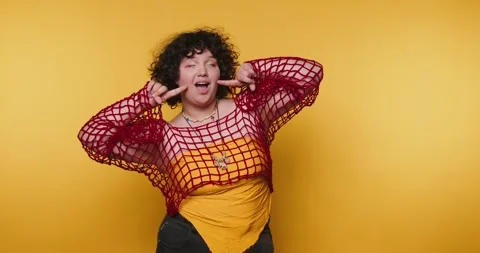 Creative and confident individual poses cheerfully against a vibrant yellow.. Stock Footage 313273934
