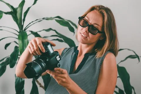 Creative and office work. Young woman photographer with glasses, smiling and  Stock Photos