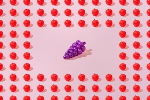 Creative apple and grape pattern flat lay on pastel pink background minimalis Stock Photos