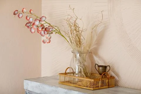 Creative arrangement of artificial branches with red petals, dried grass and Stock Photos